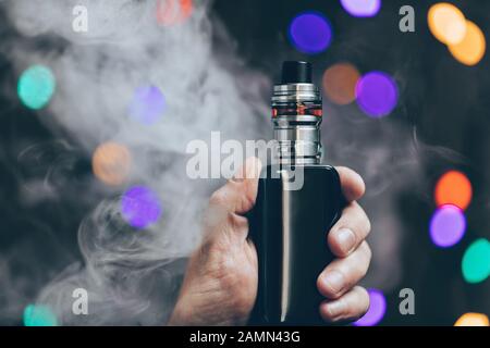 Vaping flavored e-liquid from an electronic cigarette Stock Photo