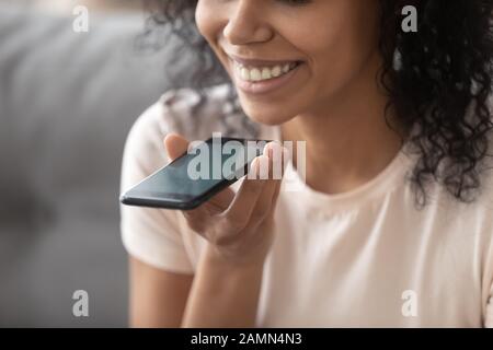 Woman speaking using loudspeaker on smartphone closeup focus on device Stock Photo