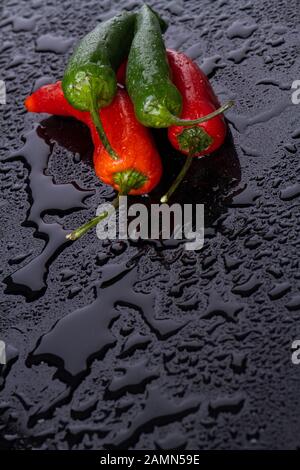 Multi-coloured peppers with tails in camera. Stock Photo