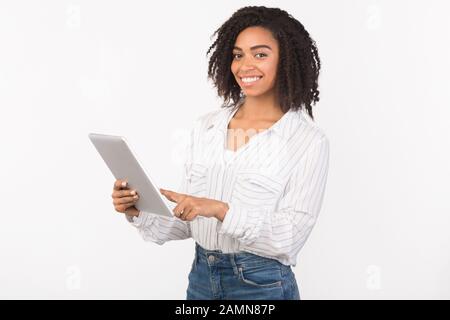 Smiling black girl standing with tablet at studio Stock Photo