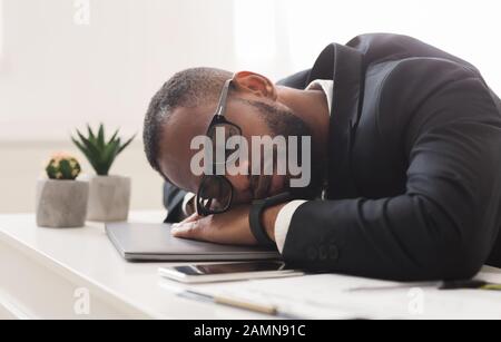 Fatigue young afro businessman sleeping in office Stock Photo