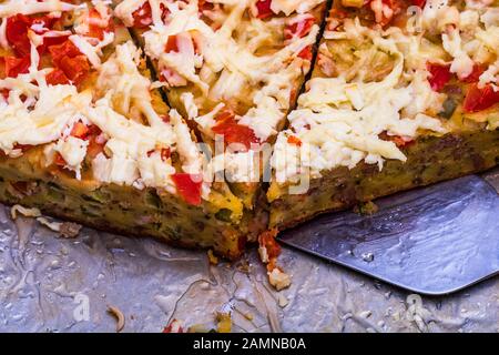 Slices of freshly baked pie with eggs, meat, vegetables and cheese.  Close up photo Stock Photo
