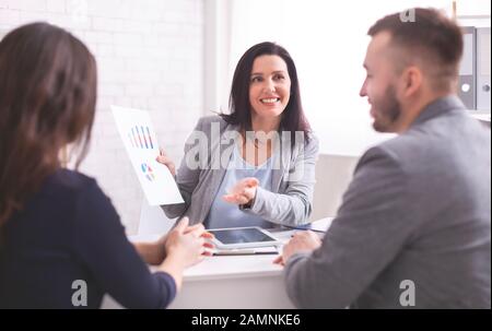 Cheerful expert explaining investment plan to new clients Stock Photo
