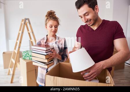 Couple packing books and lamp to the boxes Stock Photo