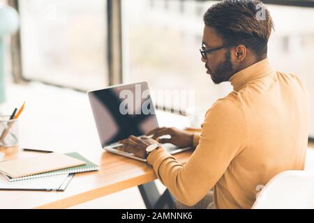 Focused black guy checking email on computer Stock Photo