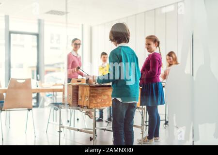 Music teacher with students in class on the xylophone Stock Photo