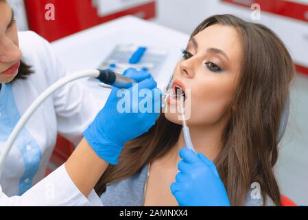 Cleaning and polishing tooth enamel in the dental office. Young girl in the dental office. Stock Photo