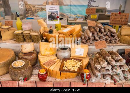 St.Gilgen, Austria - July 27,2019: Various kinds of  pecorino and parmesan cheese and salami for sale on an italian market. Stock Photo