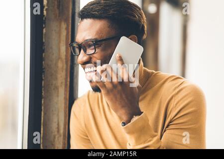 Cheerful black guy talking on the phone Stock Photo