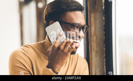 African man talking on cell phone at office Stock Photo