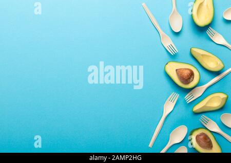 Collage of avocado and disposable tableware on blue Stock Photo
