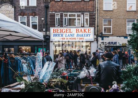 London, UK - December 29, 2019: Facade of Beigel Bake Shop in Brick Lane, people walk in front, motion blur, selective focus. Brick Lane is the heart Stock Photo