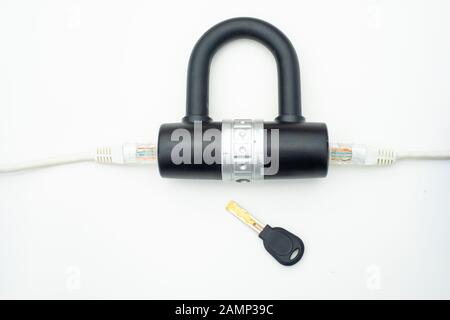 Two computer network cables going through a lock with a key, depicting digital security, cybersecurity or internet security concepts Stock Photo
