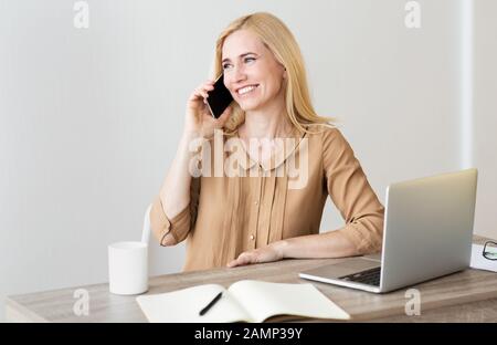 Business communication. CEO talking on phone at workplace Stock Photo