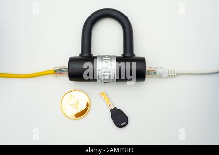 Two computer network cables going through a lock with a key and a crypto currency coin, depicting digital security, cybersecurity or internet security Stock Photo