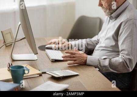 Senior man using his computer at home, he is having difficulties, elderly and technology concept Stock Photo