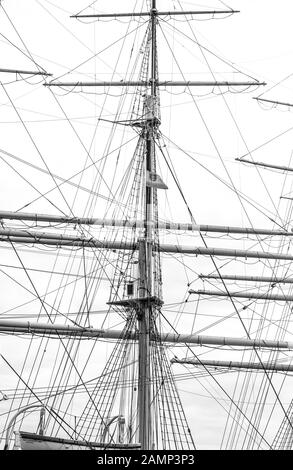 Monochrome image of mast with rigging and rolled up sails of old polish sailing ship Dar Pomorza Stock Photo