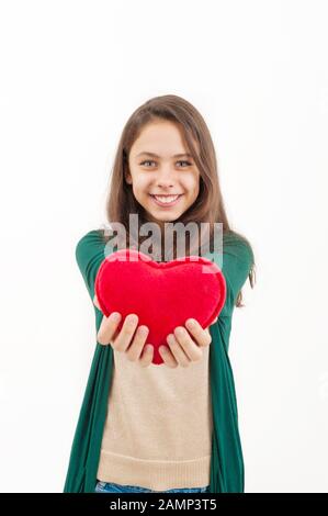 Teen girl with a plush toy heart on a white background Stock Photo