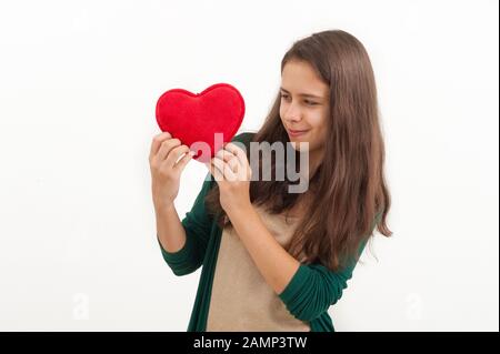 Teen girl with a plush toy heart on a white background Stock Photo