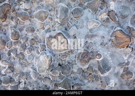 frozen water with stones background textures Stock Photo
