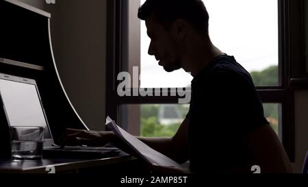 Marketer working all day, filling electronic database on laptop, freelancer Stock Photo