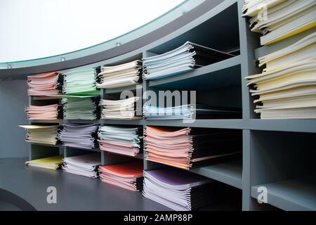 Office shelves stacked with multi-coloured folders and documents. Stock Photo