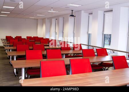 An empty lecture or seminar room with red chairs. Stock Photo