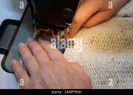 Close up shot of a seamstress operating a sewing machine. Stock Photo