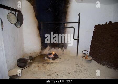 An open fireplace in a traditional old-fashioned Irish cottage. A stack of turf can be seen on the right of the photo. Stock Photo