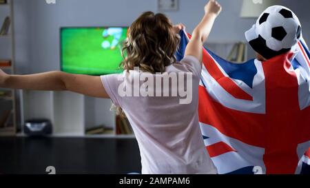 Fans from Britain watching football match at home, cheering and supporting team Stock Photo