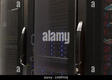 Close up shot of a date centre cabinet. Lights and cables can be seen behind mesh doors. Stock Photo