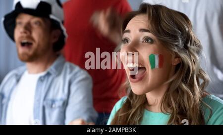 Italian supporters celebrating victory of national team, watching match in pub Stock Photo