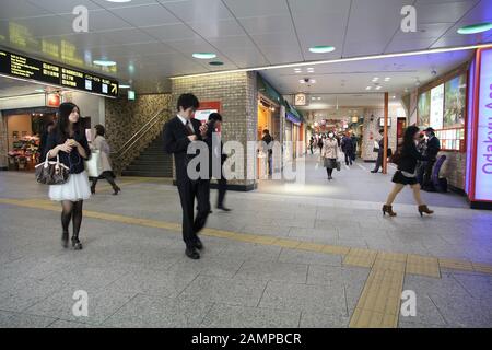 TOKYO, JAPAN - APRIL 13, 2012: People walk at Shinjuku Station in Tokyo. It is the world's busiest transport hub with daily usage by up to 3.64 millio Stock Photo