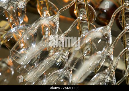 Drinking glasses hanging from a rack in a bar or restaurant. Stock Photo