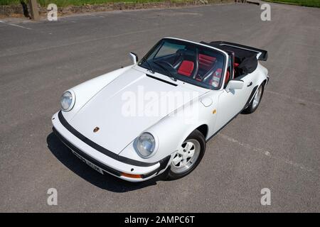 White nineteen Eighties Porsche 911 cabriolet with black and red leather interior and body coloured Fuchs alloy wheels Stock Photo