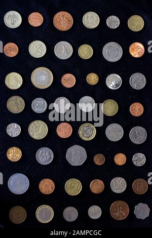 Various types of coins of different shapes, sizes and of different compositions from various countries on a black background