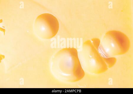 Emmental cheese texture close up. Macro Swiss yellow cheese with holes background Stock Photo