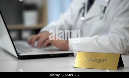 Urologist prescribing medication for cystitis, doctor completing medical form Stock Photo
