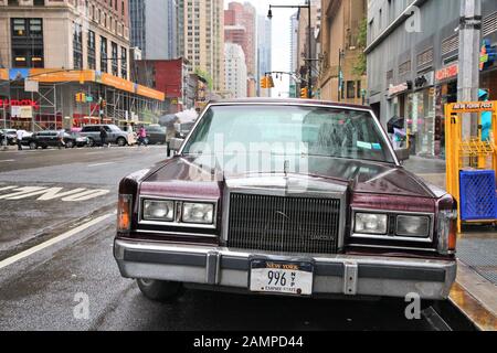 NEW YORK, UNITED STATES - JUNE 10, 2013: Old Lincoln car parked at rainy 8th Avenue in New York. Lincoln Motor Company is part of Ford corporation and Stock Photo