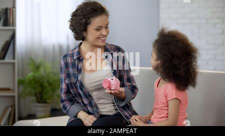 Mum telling daughter about family budget planning, financial education for kids Stock Photo