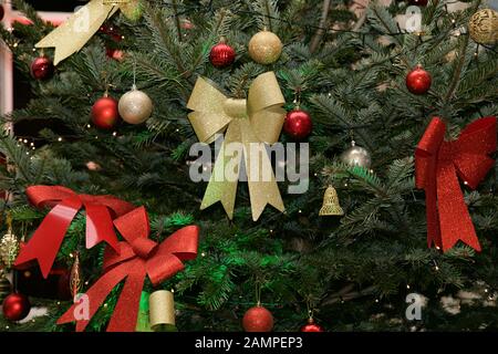 Christmas background: close up shot of a decorated Christmas tree with ribbons and baubles. Stock Photo