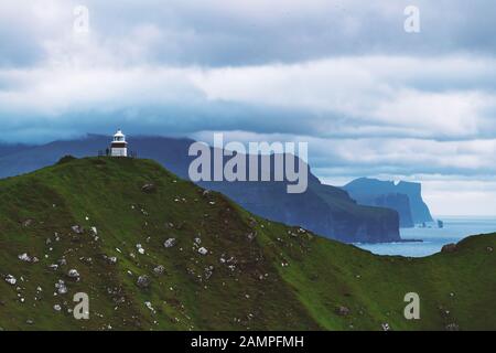 Panorama with Kallur lighthouse on green hills of Kalsoy island, Faroe islands, Denmark. Landscape photography Stock Photo
