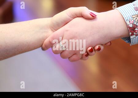 Close up shot of two women shaking hands. Stock Photo