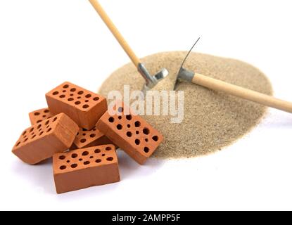 Bricks and building sand against a white background Stock Photo