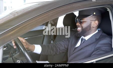Smiling business driver sitting in luxury automobile, transportation service Stock Photo