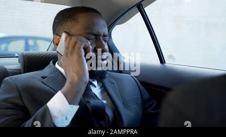 Stressed man having unpleasant phone conversation, marriage problems, bankrupt Stock Photo