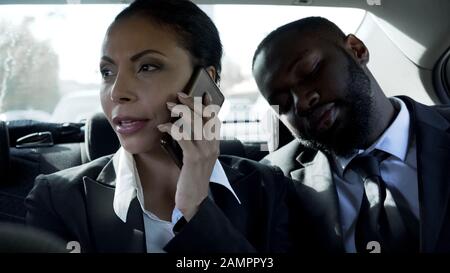 Pretty businesswoman talking on phone in car, man flirting with lady, lovers
