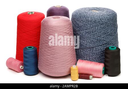 Cones and spools of synthetic or cotton threads on white background. Spool of yarn using for weaving in textile manufacturing Stock Photo
