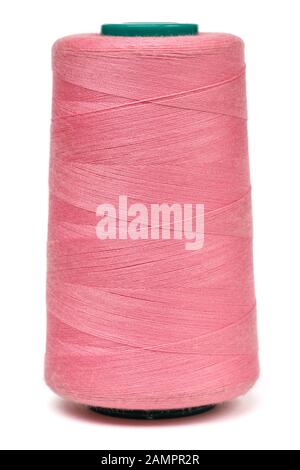 Spool of pink synthetic or cotton threads isolated on white background. Spool of yarn using for weaving in textile manufacturing Stock Photo