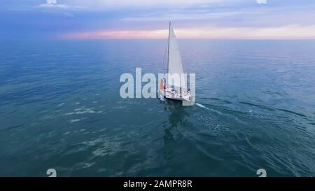 Boat sailing in ocean with couple standing at bow, future opportunities, freedom Stock Photo